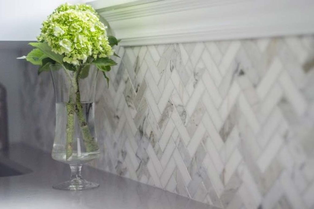 herringbone tile kitchen sink window backsplash grey and white green flower