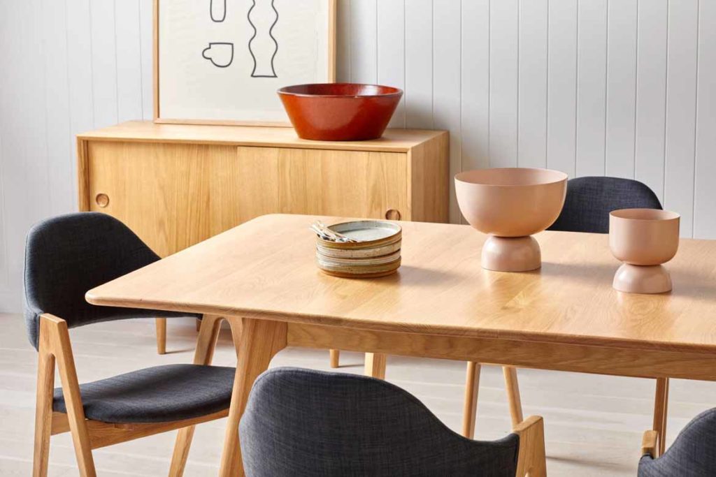 timber wooden dining table in living room with navy chairs