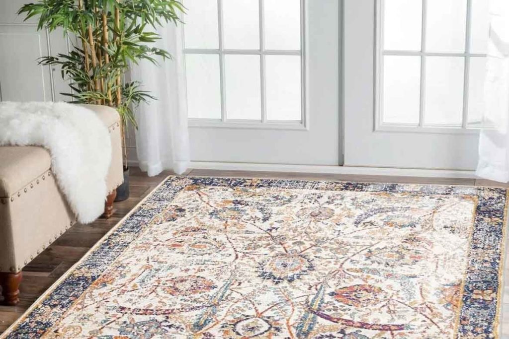 traditional blue persian rug in modern living room home with beige couch and french doors windows and plant