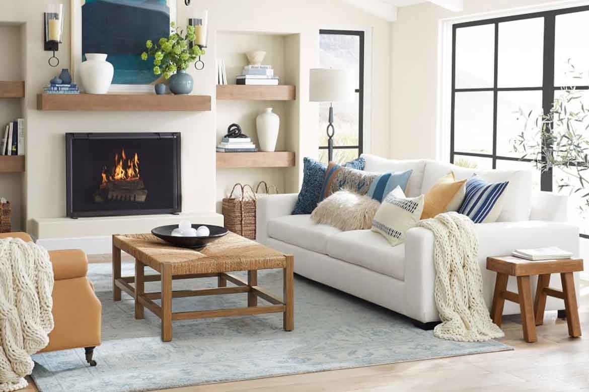 white lounge room living room with blue persian rug large windows and fireplace
