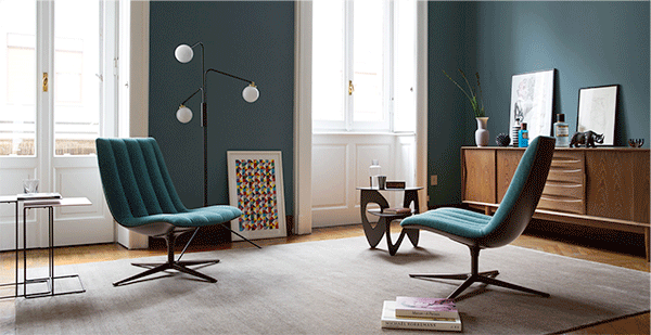 Healey Lounge, designed by PearsonLloyd. The ultimate mood piece. Healey Lounge is a modern chair that supports the rituals of our everyday medial life. The outer shell carries the soft upholstery – underlined by the distinctive piped quilting. A genuine tribute to the seats of legendary classic cars. Flowing lines trace the shape precisely. An elegant shell envelops the seat and armrests.  A tool for modern life: the broad upholstered armrest. Easily adjustable for comfort and as a surface for a tablet or smartphone. Healey Lounge reveals its personality whether as a soloist or in an informal get-together – lightweight, casually elegant, comfortable, on a swivel base. And you know what they say: how monotonous would life be without extravagant characters?