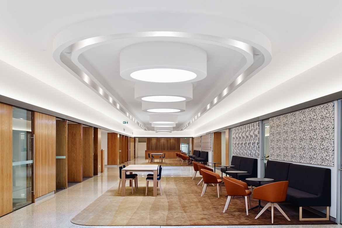 Looking down the length of the Darwin Innovation Hub, a long space with seating and a sculptural white ceiling by Georgina Wilson Associates.