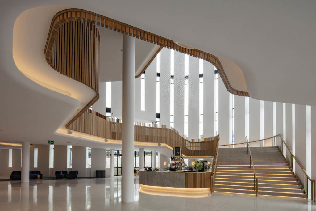 Wood panels border the sweeping staircase in the white atrium of Sydney Coliseum Theatre.