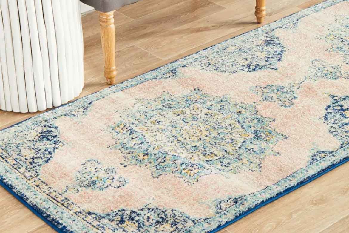 light blue subtle persian rug on hardwood floors with laundry basket