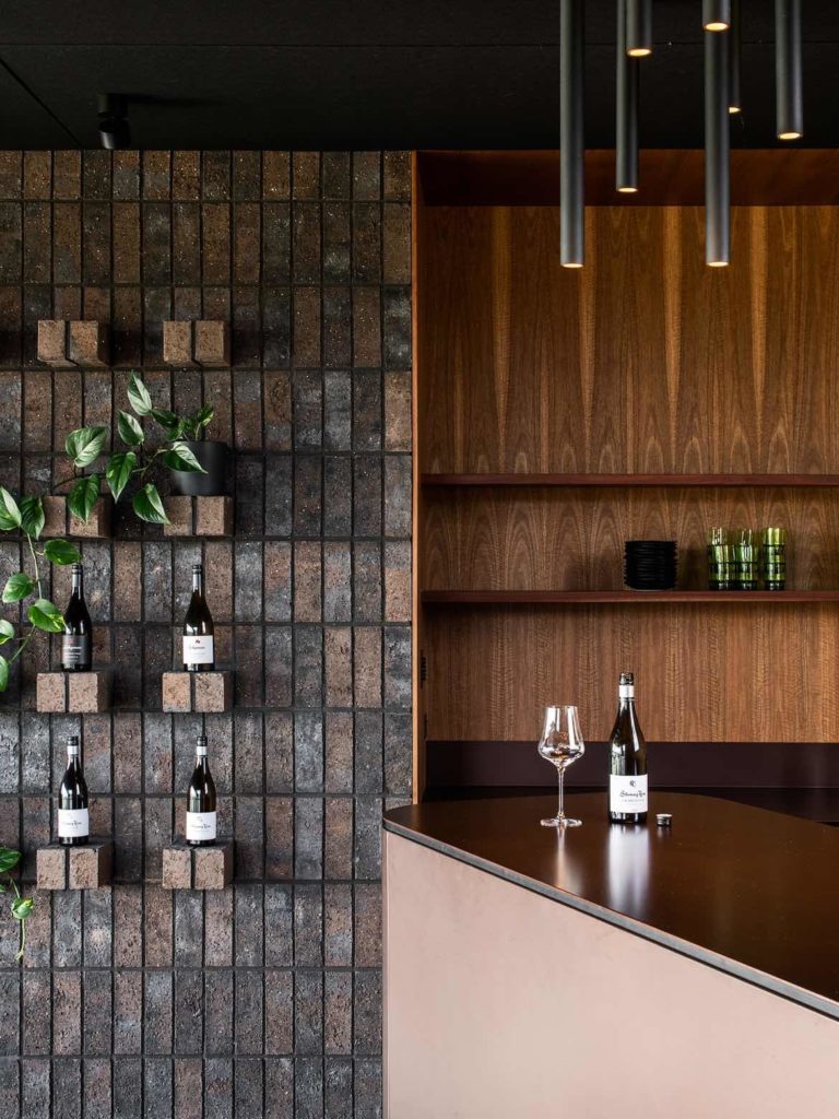 Locally sourced bricks have protruding headers, acting as plinths for Stoney Rise wines.