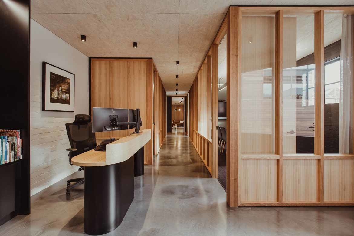 Light grey epoxy concrete floors are paired with Tasmanian oak and touches of black in the ERA office by Cumulus.