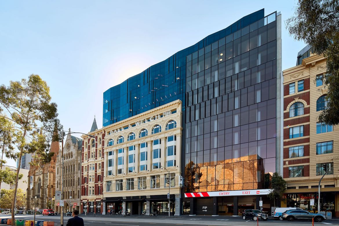 Black glass and historic yellow exterior of Hub Flinders Street.