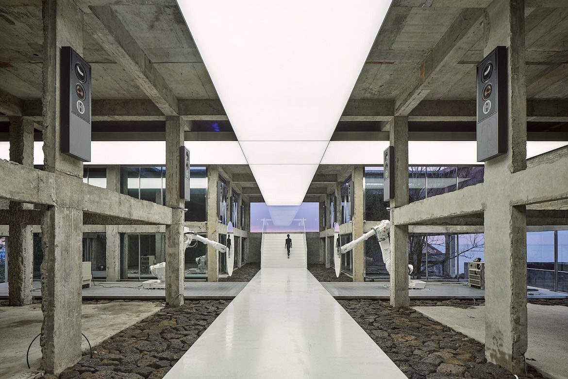 The white walkway through the centre of Gongbech gallery with an illuminated white strip overhead.