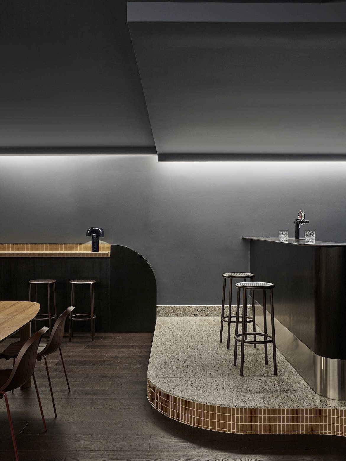 Split terrazzo and wood floor in The Stables’ basement by State of Kin.