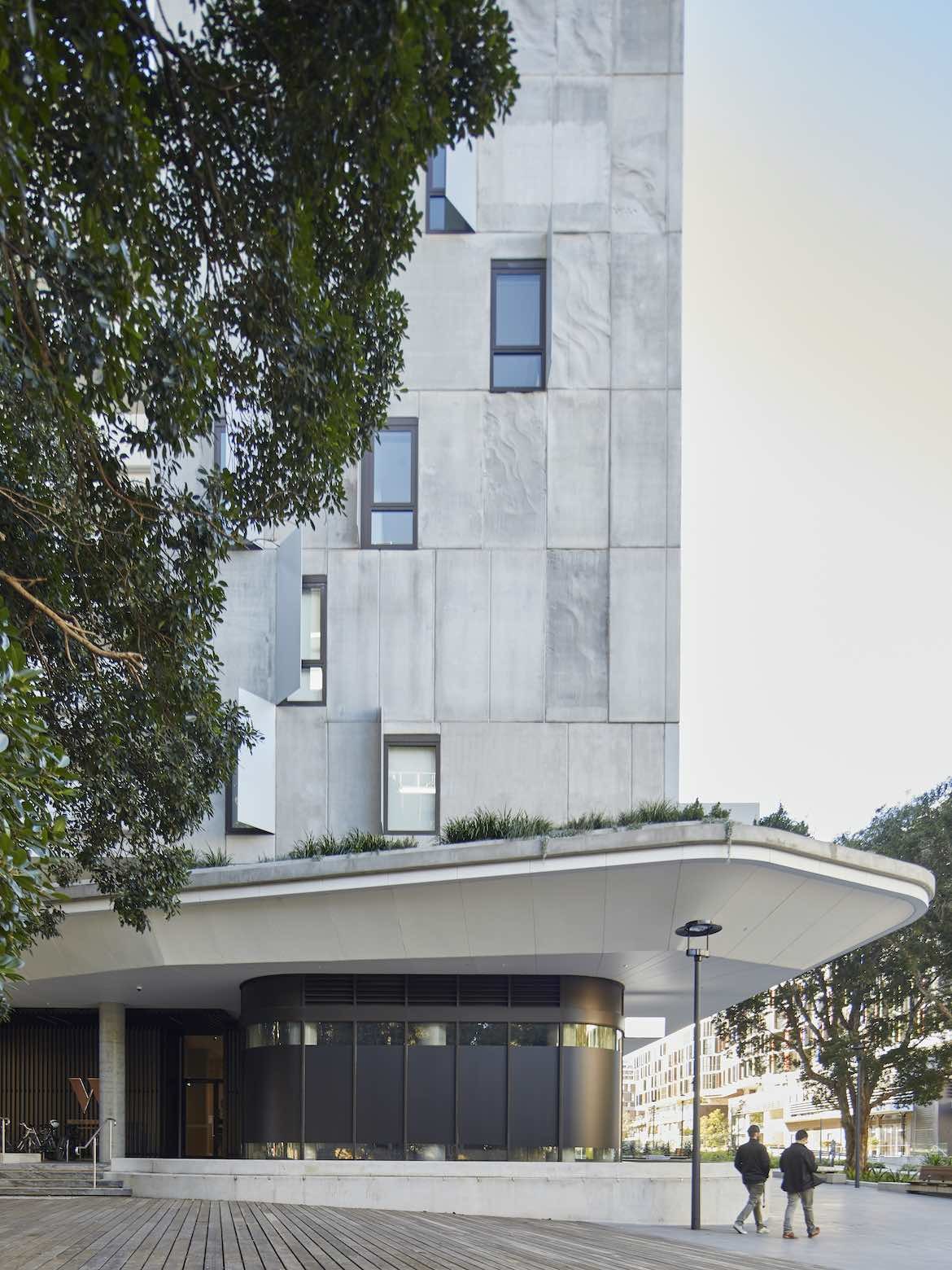 Two men walk past the exterior of Waterfall by the Crown group.