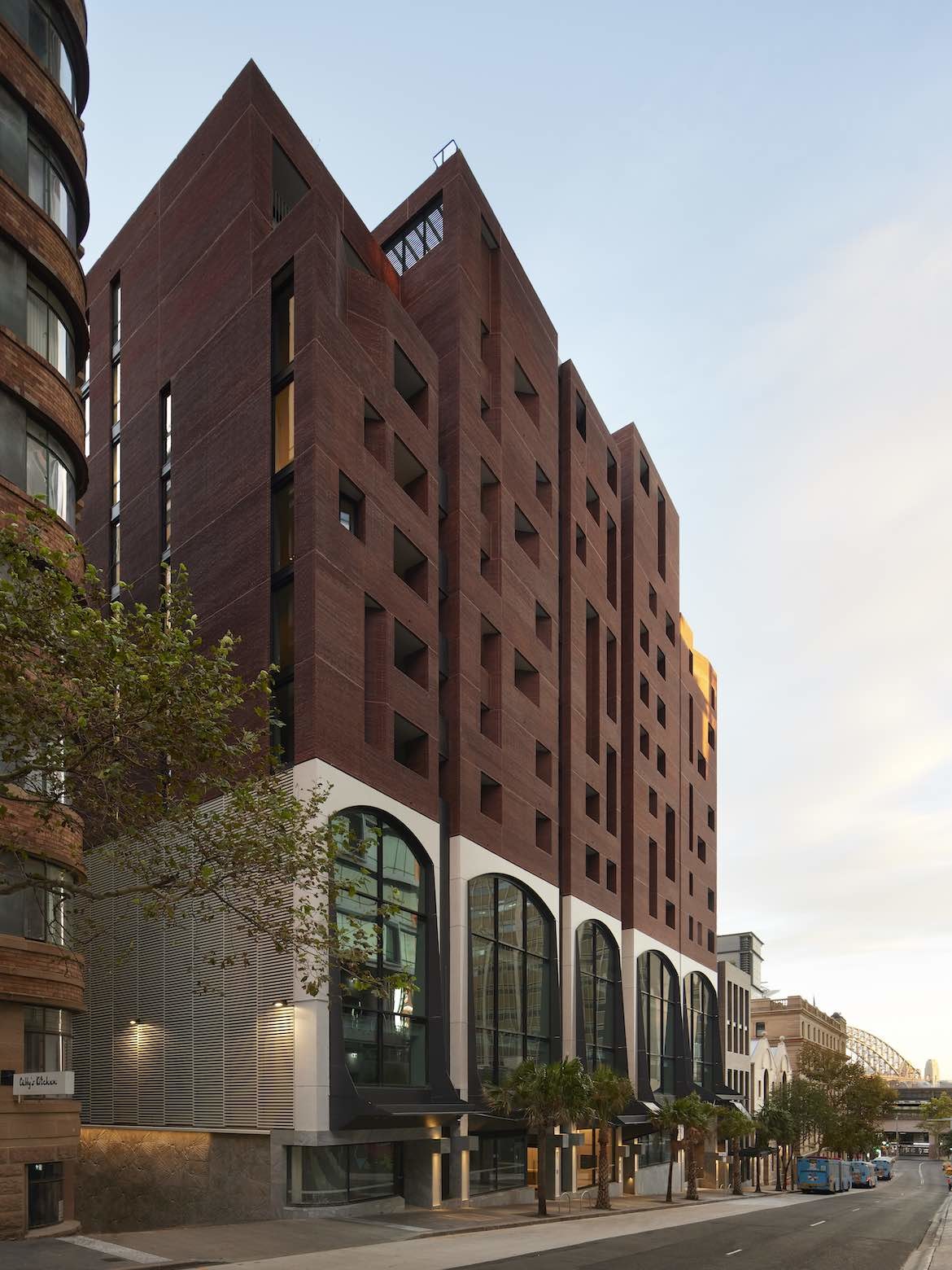 The red exterior with large windows of the Quay Quarter Lanes mixed-use development by SJB.