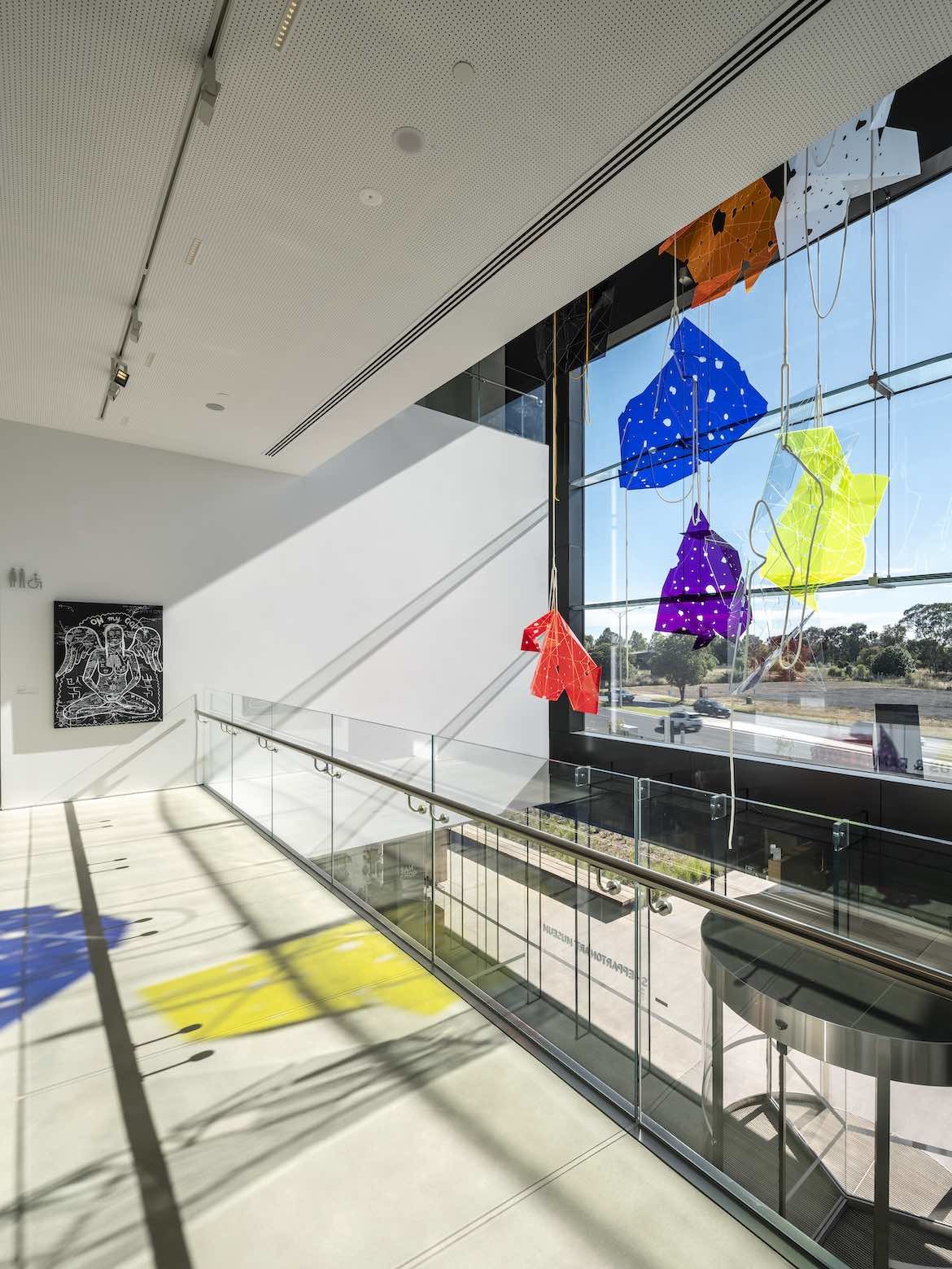 A colourful hanging installation hangs over a void in SAM, Shepparton Art Museum.