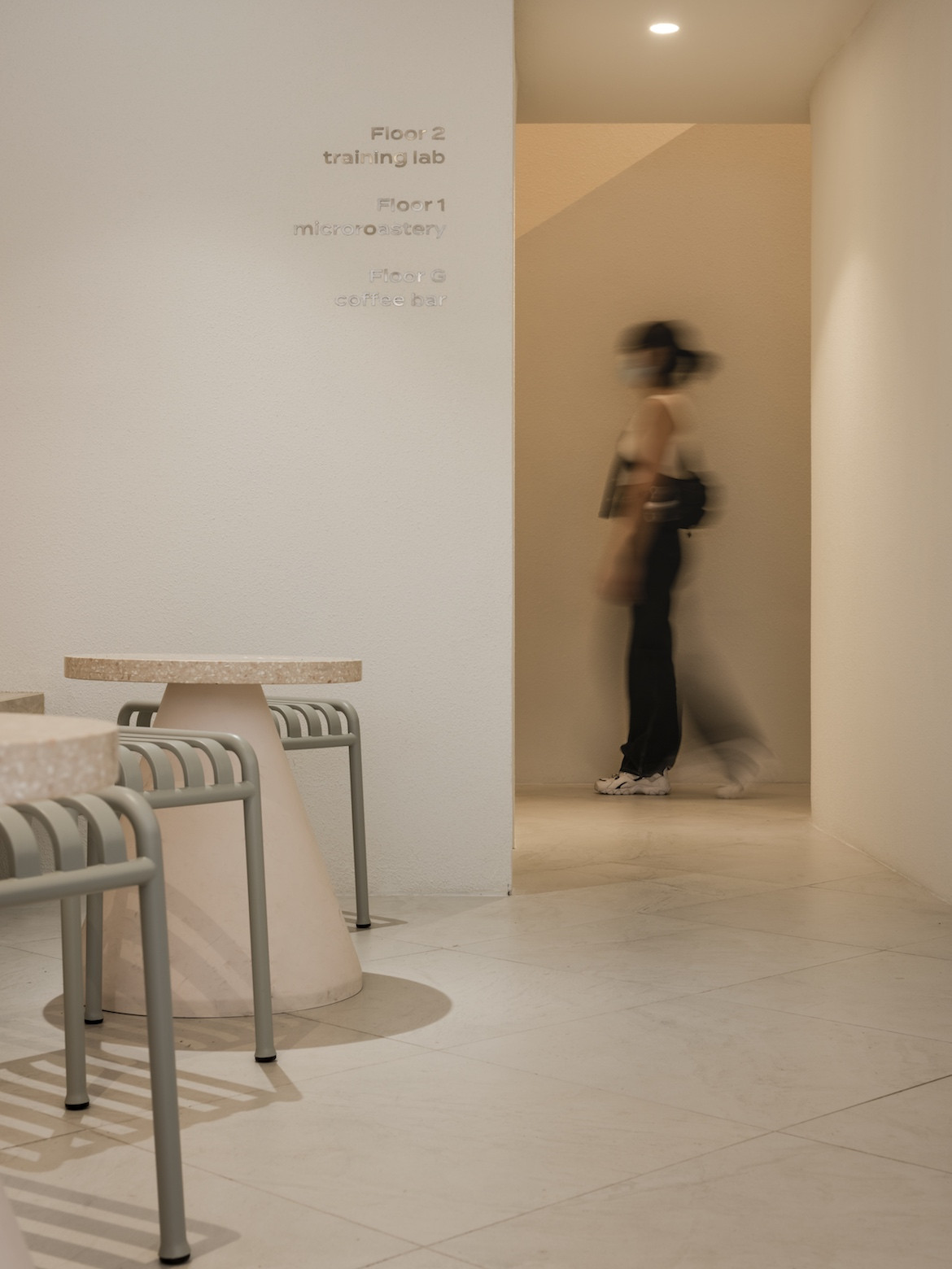 A person walks through a doorway in Exterior of PAGA Microroastery.