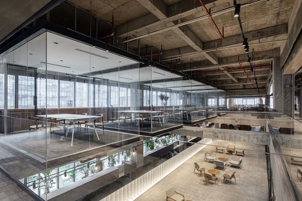 Exposed ceilings and meeting rooms with transparent walls feature in the Yeahka office by JSPA Design.